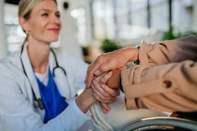 octubre rosa, acercamiento a manos de paciente entrelazadas con manos de doctora