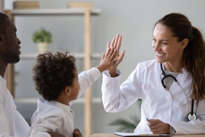 perspectiva de género en salud, doctoral chocando su mano con niño en consulta