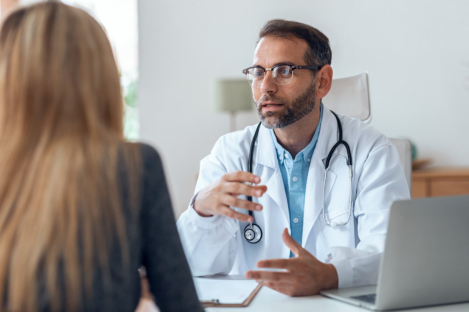 doctor hablando con paciente mujer en consulta