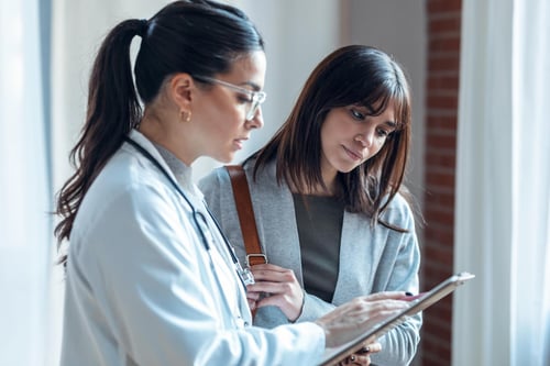 marketing digital médico, tendencias, doctora mujer con lentes mostrando tablet a otra mujer